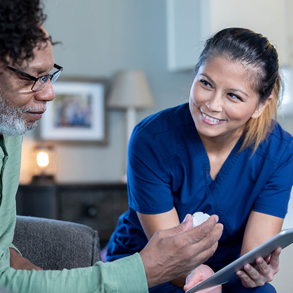 Home healthcare nurse with senior man and his adult daughter